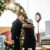a couple strolls in front of a decorated arch at Christmas in Le Mars
