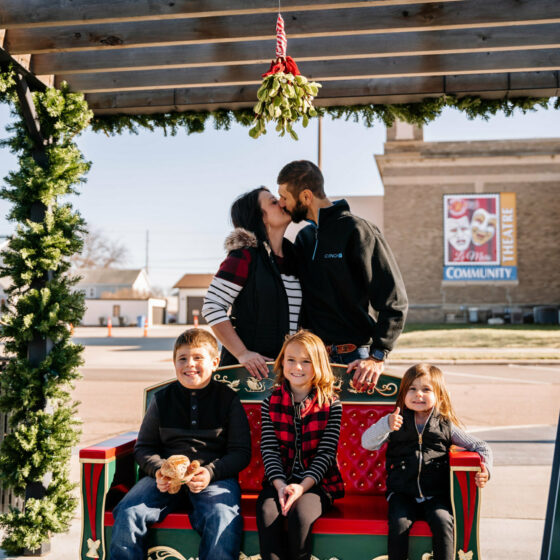 A couple kissings under mistletoe at Christmas in Le Mars