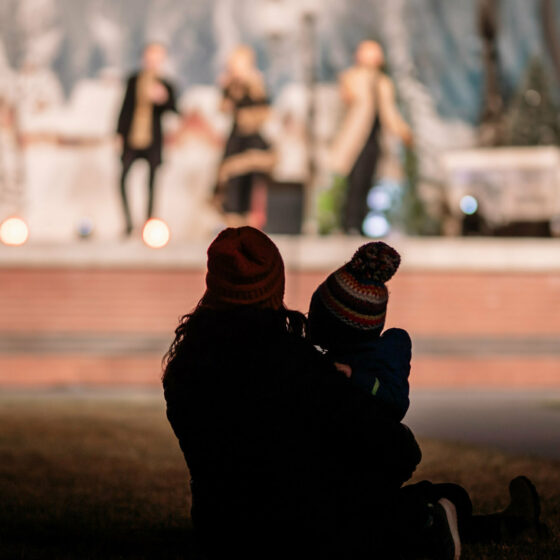 A mom holds her child while watching a concert at Christmas in Le Mars