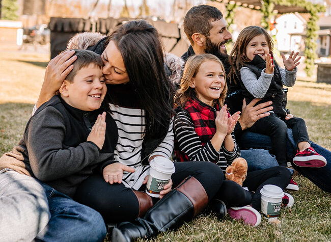 A family sits in a park on the grass enjoying the festivities at Christmas in Le Mars Iowa