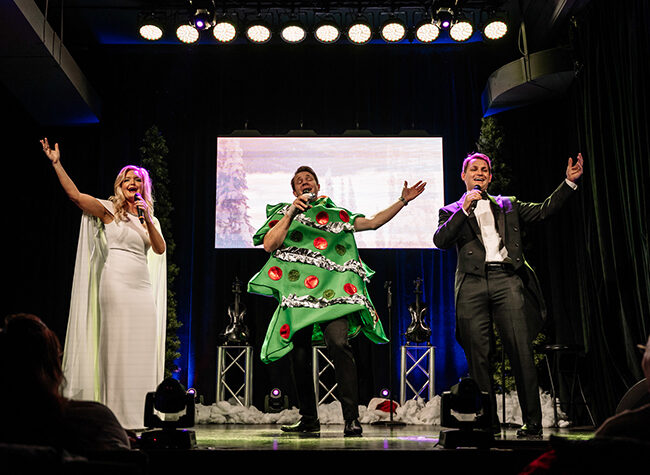 Performers sing for a crowd dressed in holiday gear for Christmas in Le Mars